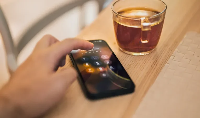 Hand unlocking a smartphone, illustrating signs your phone may be tracked