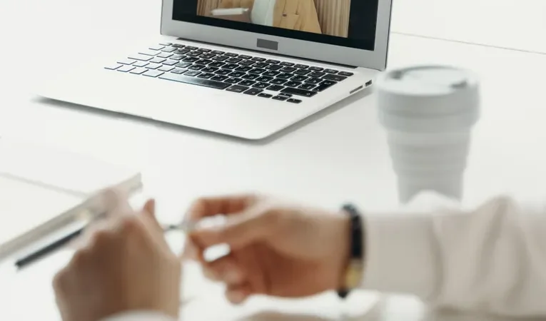 Laptop screen showing a professional video call meeting, illustrating the Cluely AI review