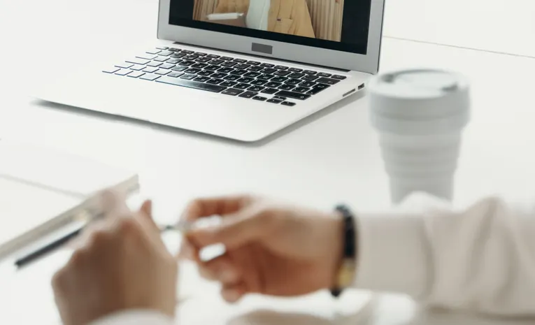 Laptop screen showing a professional video call meeting, illustrating the Cluely AI review