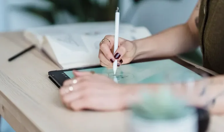 Designer sketching on a digital tablet, illustrating the Flora AI creative canvas review