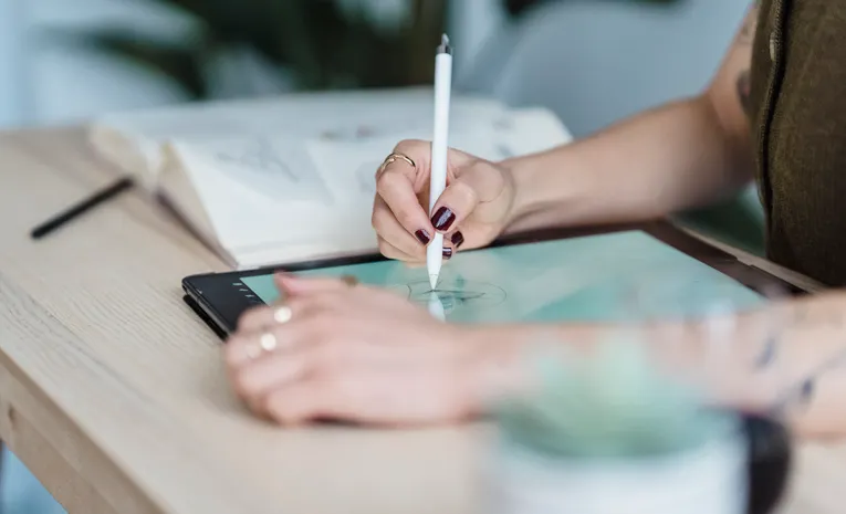 Designer sketching on a digital tablet, illustrating the Flora AI creative canvas review