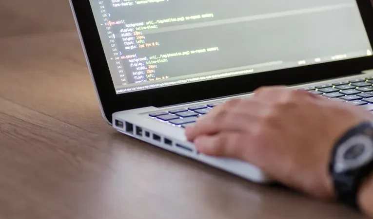 Person coding on a laptop, illustrating the Mocha AI no-code app builder review